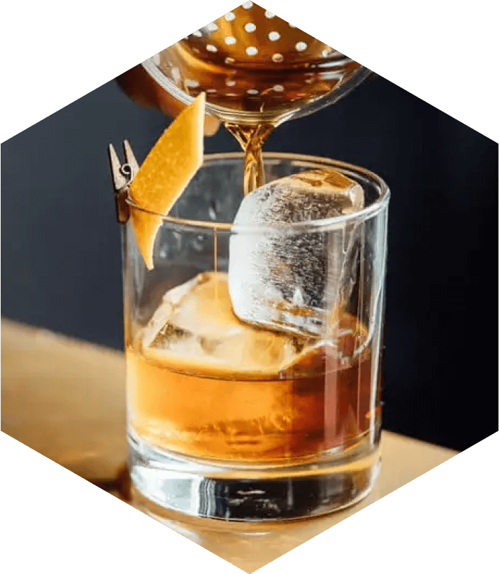 Highwing whiskey being poured into a rocks glass with an orange peel for garnish.